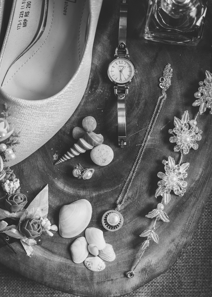 Classy accessories and shoes arranged with flowers and seashells